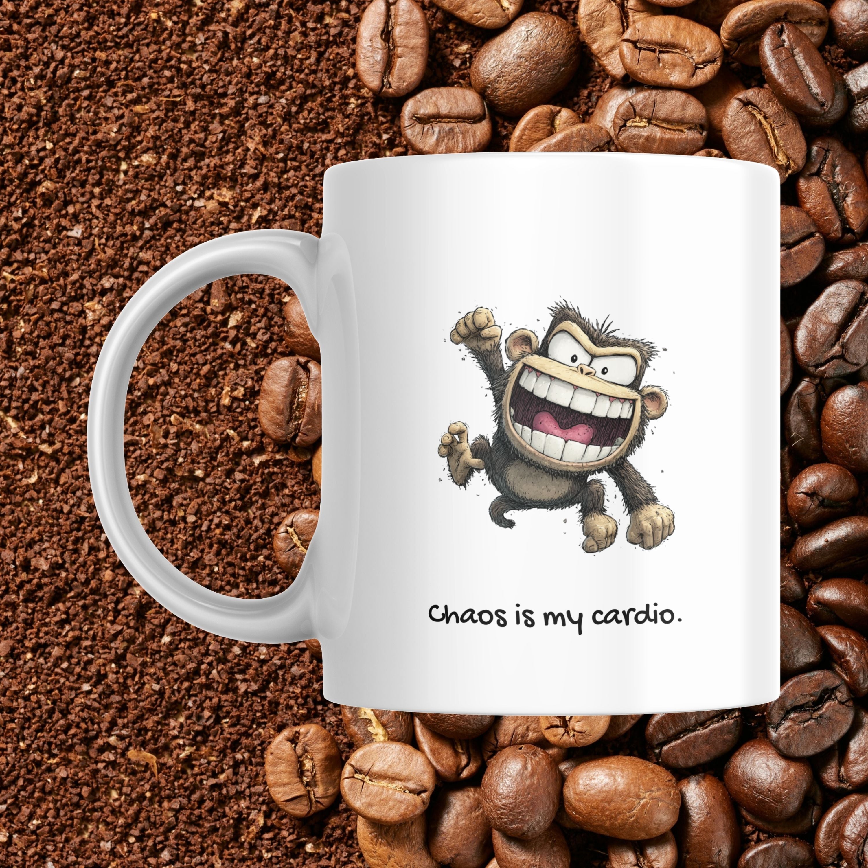 White mug with a cartoon monkey design and 'Chaos is my cardio' text, surrounded by coffee beans.