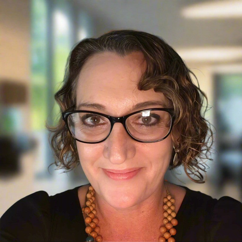 Woman wearing glasses with a blurred indoor background