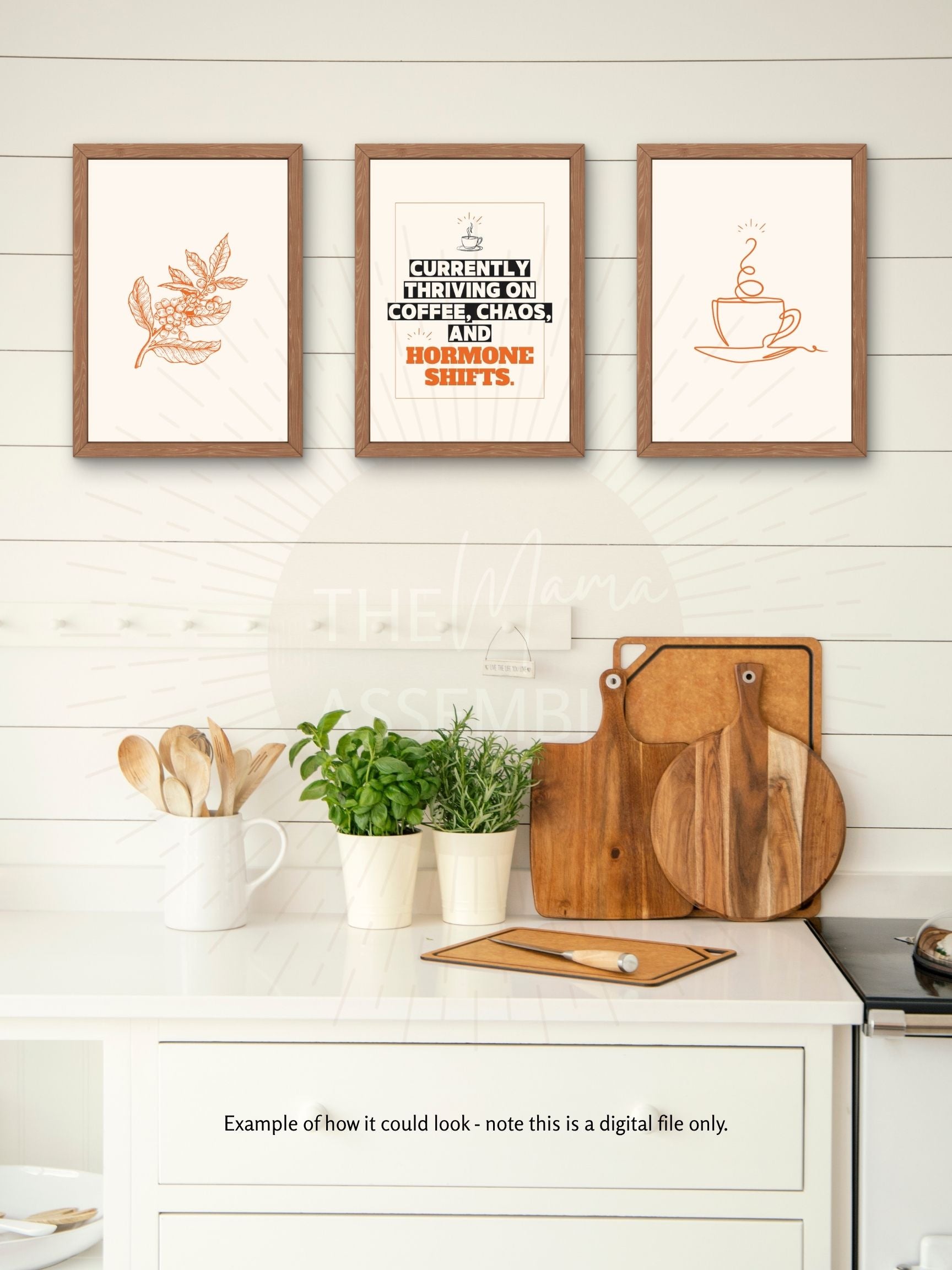 Three framed prints on a kitchen wall with wooden cutting boards and utensils below.
