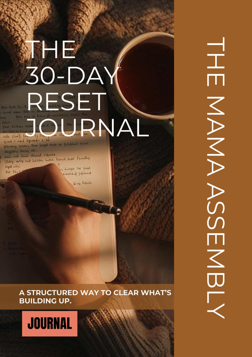 Book cover of 'The 30-Day Reset Journal' by The Mama Assembly with a hand writing in a journal next to a cup of coffee.