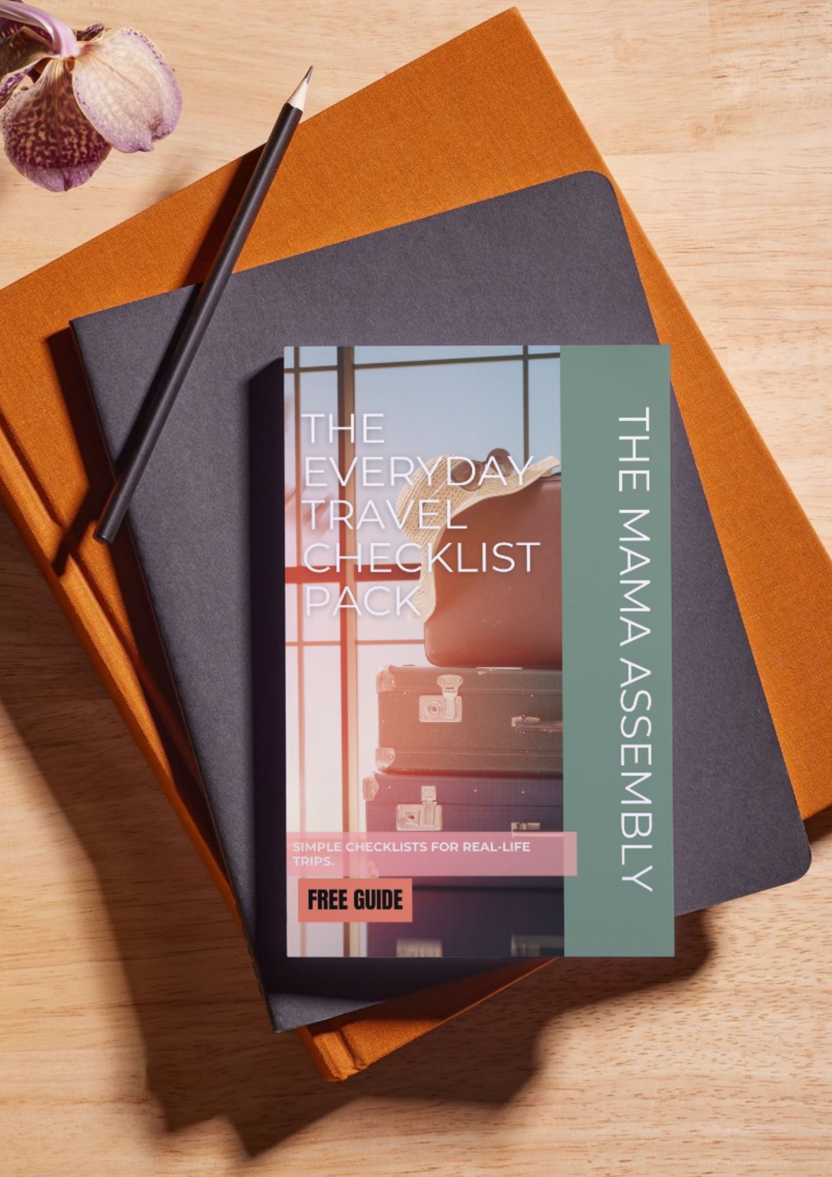 Travel checklist pack by The Mama Assembly on a wooden surface with a pen and notebook.