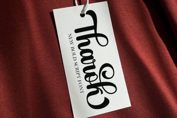 White tag with black script font on a red fabric background