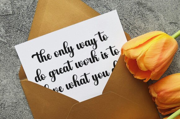 Motivational card with quote in an envelope next to orange flowers on a textured surface
