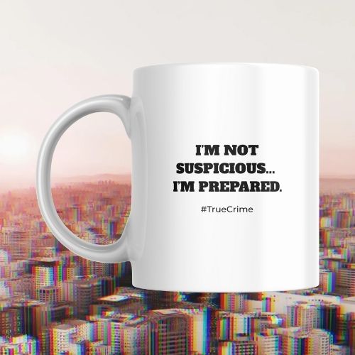White mug with text 'I'm not suspicious... I'm prepared.' and '#TrueCrime' on a cityscape background.