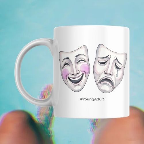 White mug with comedy and tragedy masks and '#YoungAdult' text on a blue background