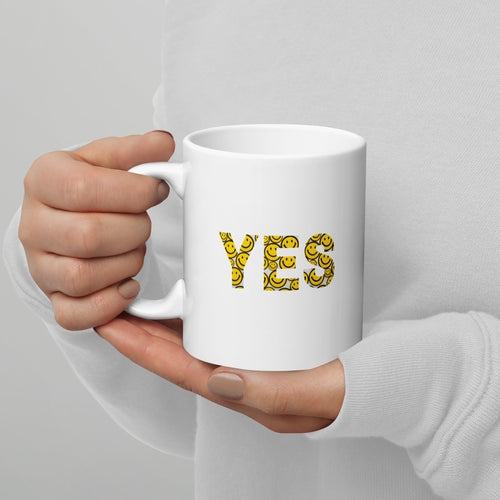 White mug with 'YES' printed in yellow on a gray background