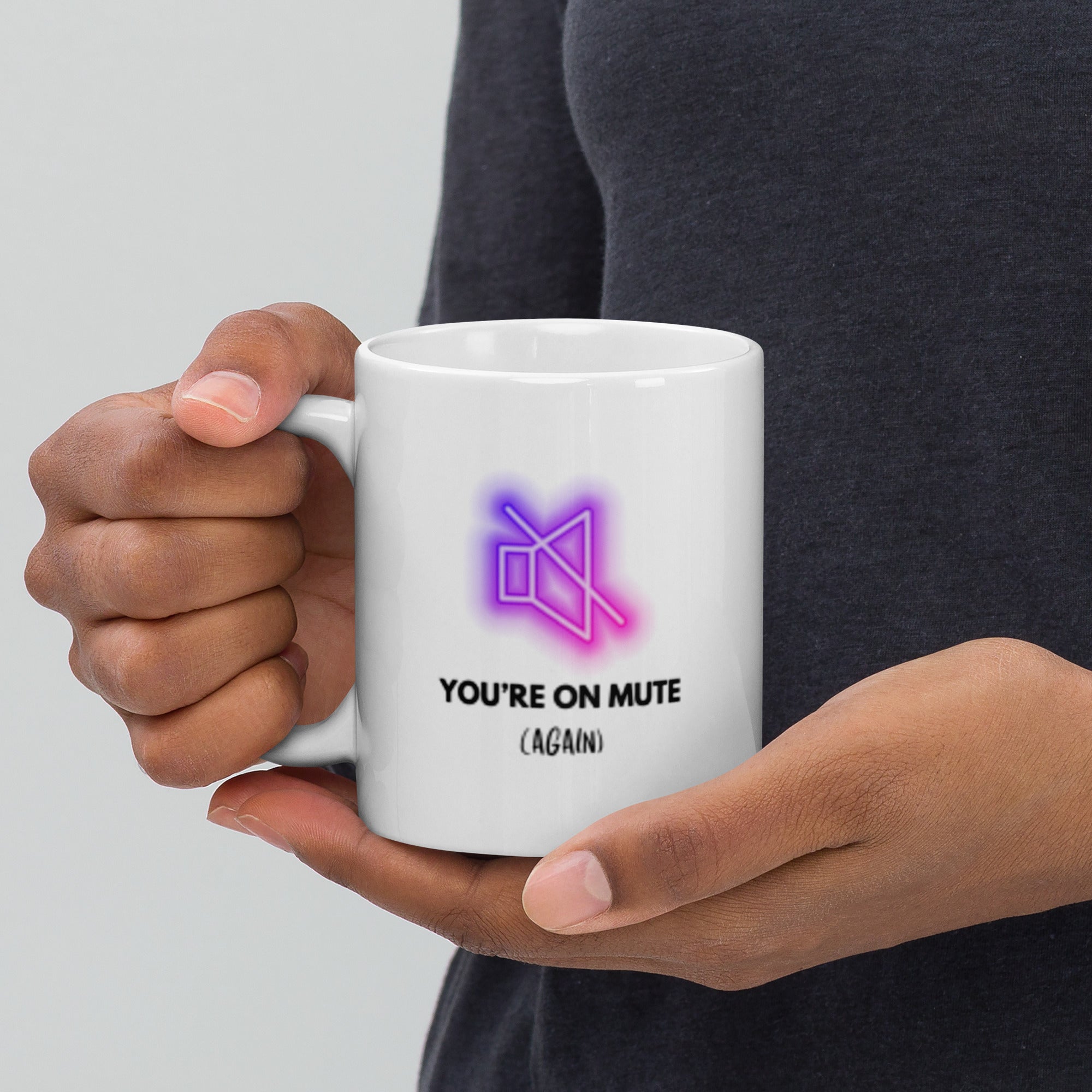 Person holding a white mug with a neon design and text on a light gray background