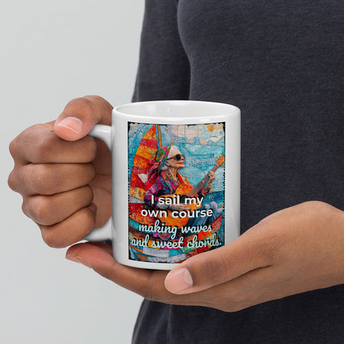 Person holding a mug with a colorful design and text on a plain background
