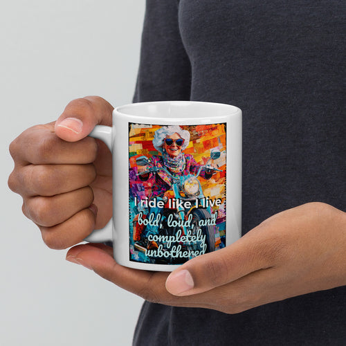 Person holding a mug with a colorful design and text on a plain background