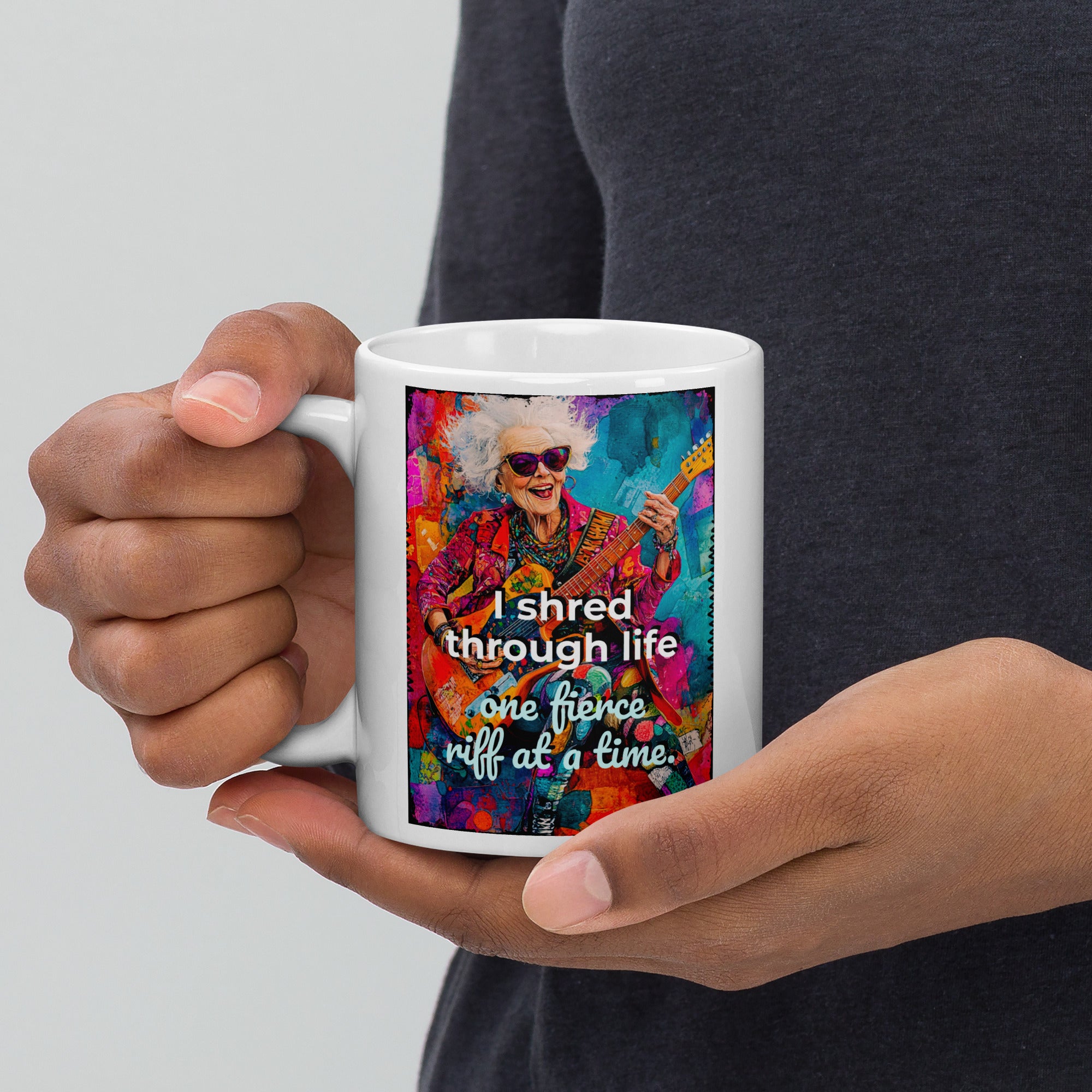 Person holding a mug with a colorful design and text on a plain background
