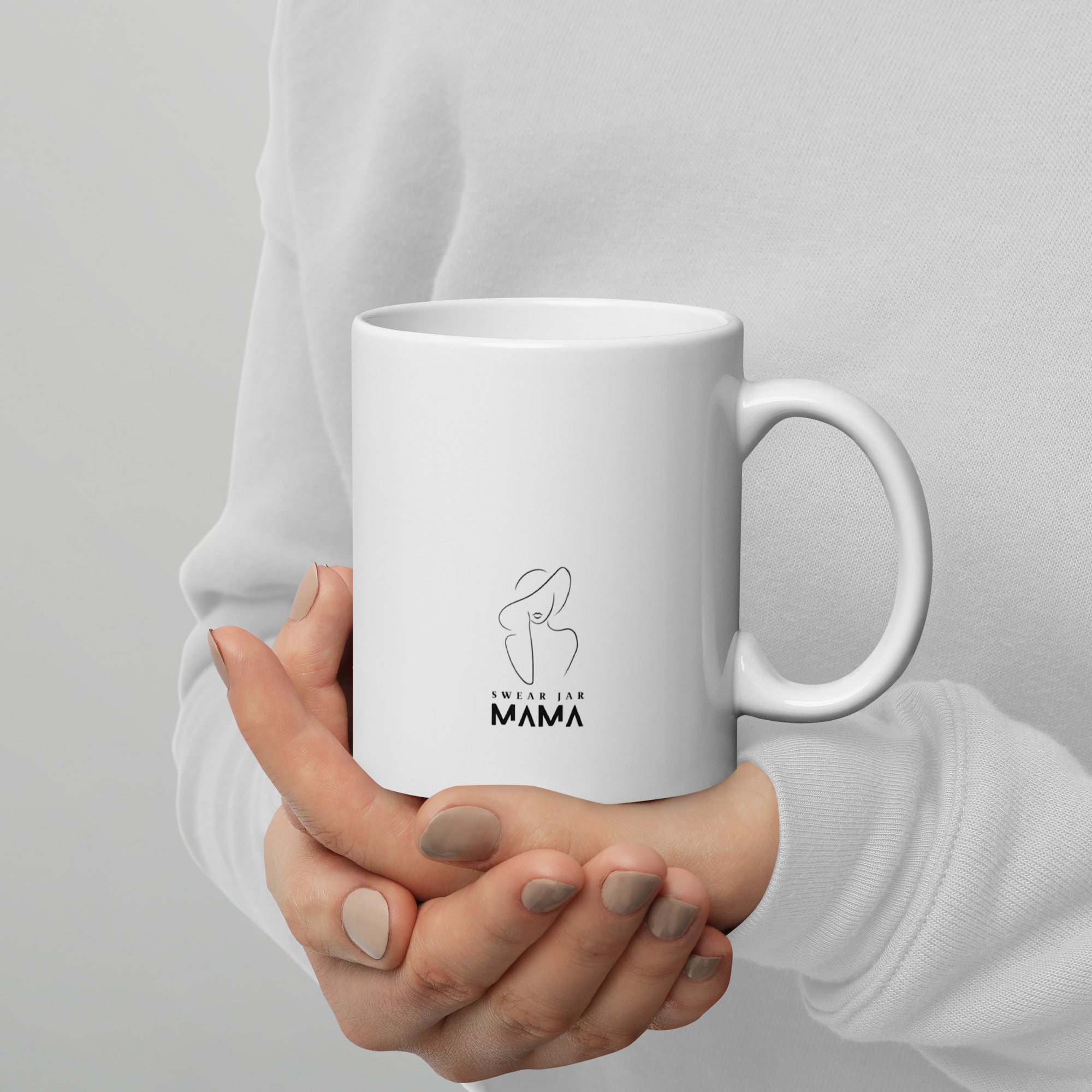 White mug held by a person with a design and text on a light gray background