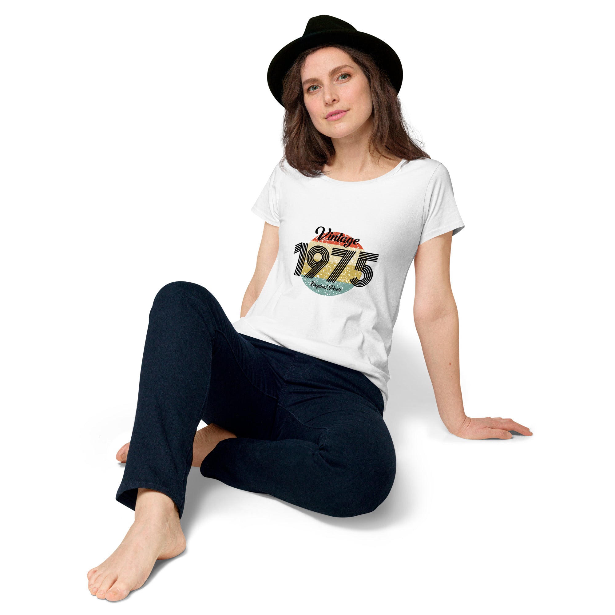 A woman wearing a white women's t-shirt with 'Vintage 1975' printed on the front.